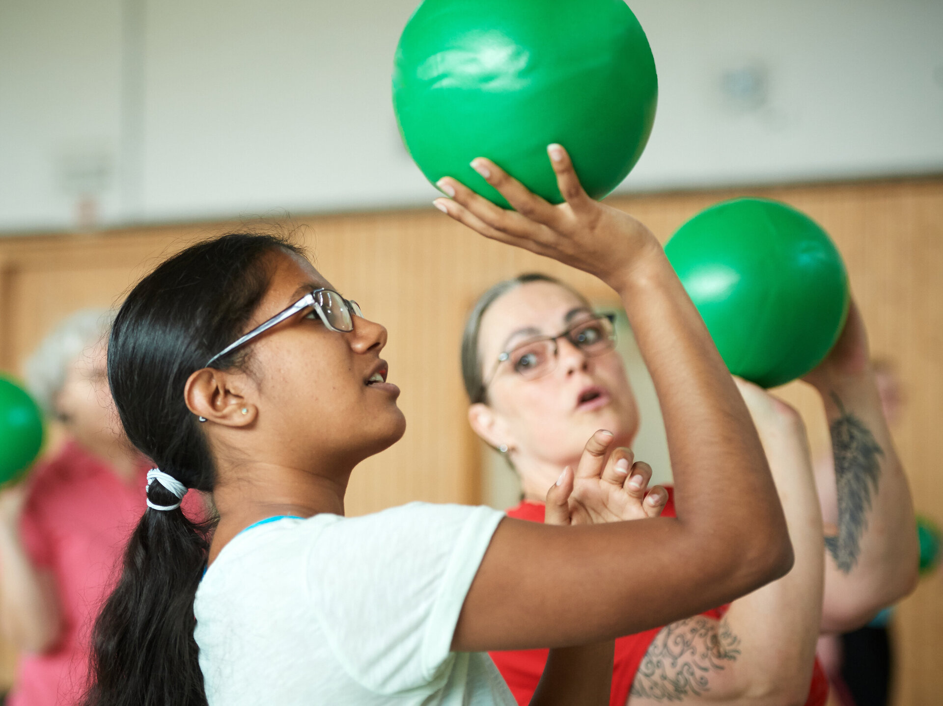 Menschen beim Funktionstraining mit grünen Bällen