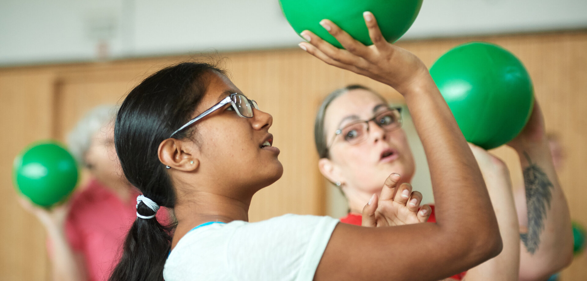 Menschen beim Funktionstraining mit grünen Bällen