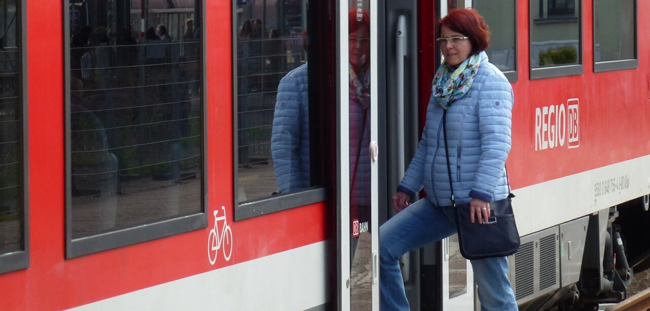 Frau steigt in Bahn ein