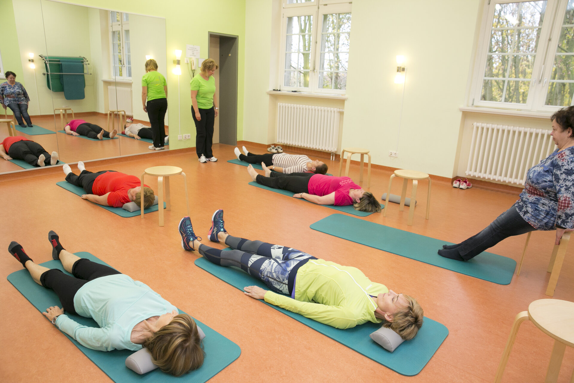 Mehrere Personen auf Yogamatten liegend