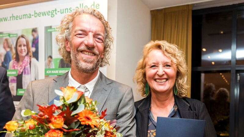 zwei Menschen mit Blumensträußen Auszeichnung