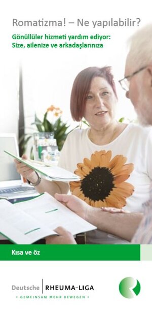 Frau mit Sonnenblumenprint auf Tshirt hält Broschüre in der Hand 